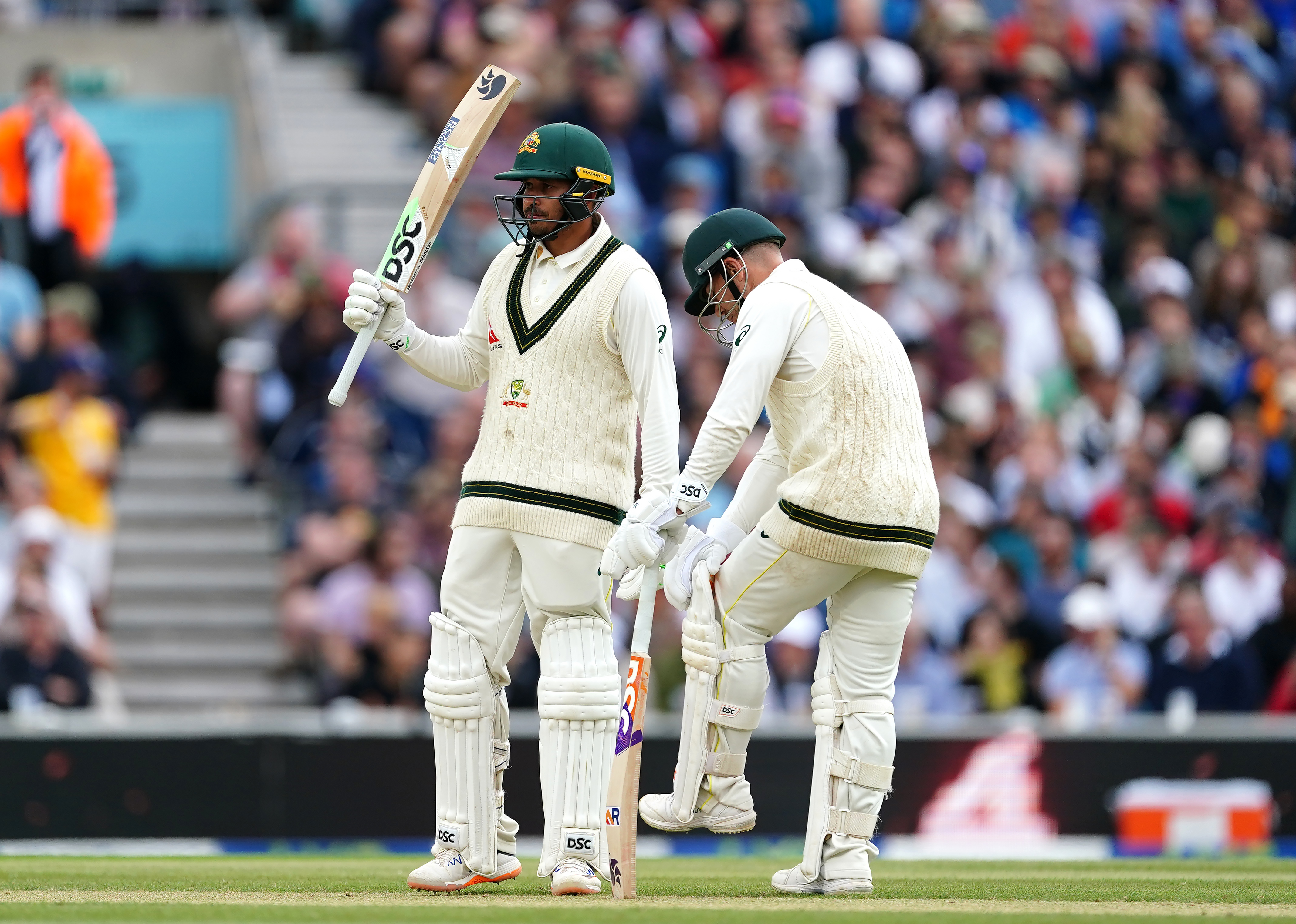 Usman Khawaja, left, celebrates his half-century with David Warner