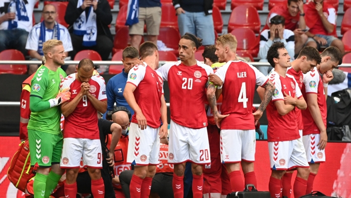 Denmark's players gather around Christian Eriksen at Euro 2020