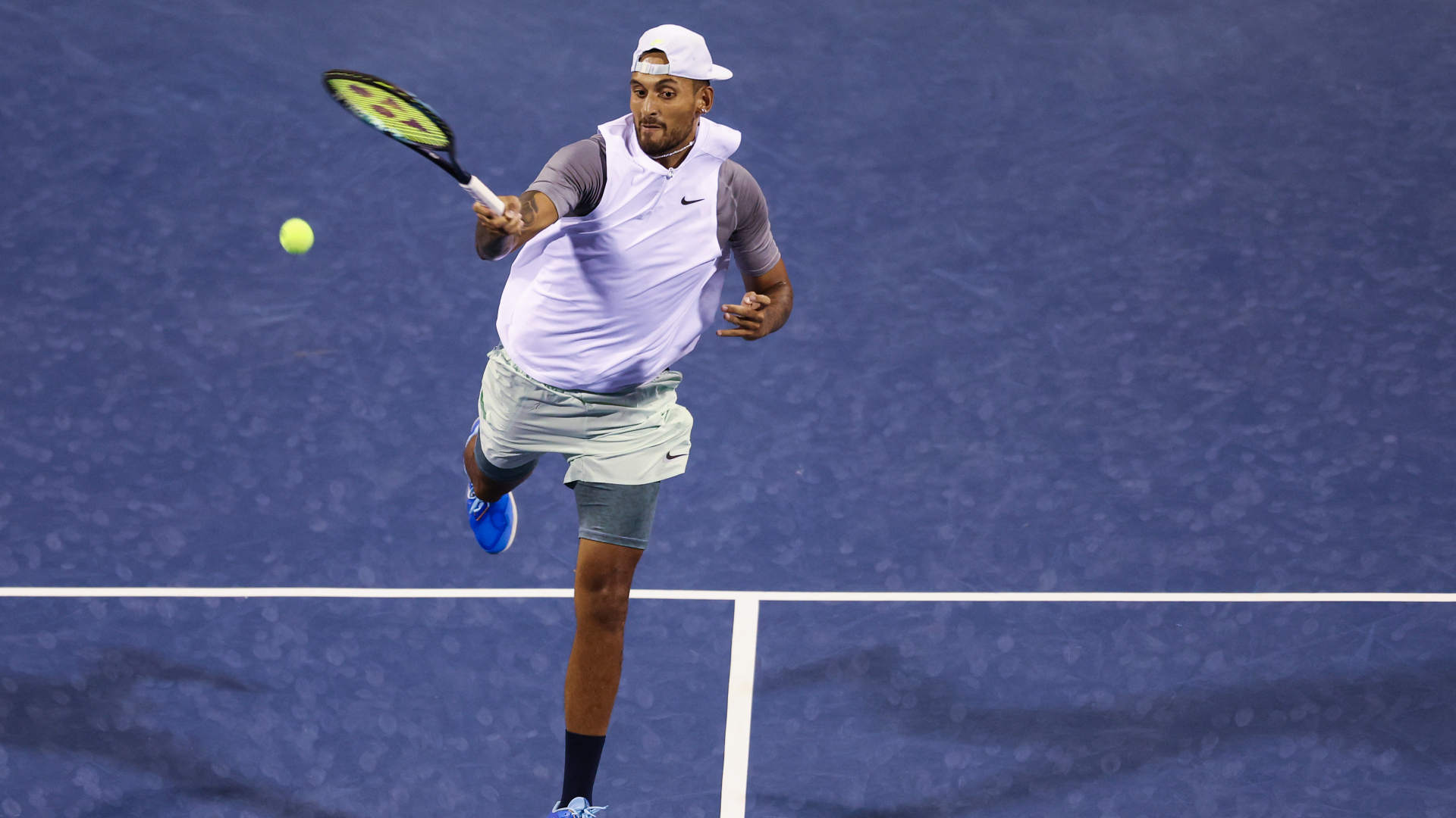 Nick Kyrgios finishes off a point in his first of two matches on Friday