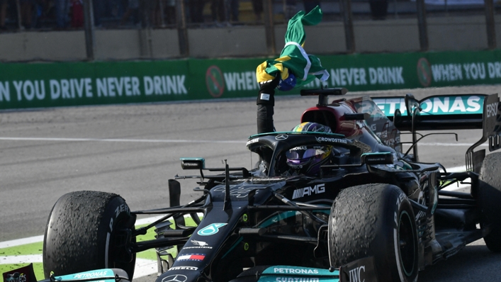 Lewis Hamilton waves a Brazil flag after his grand prix win