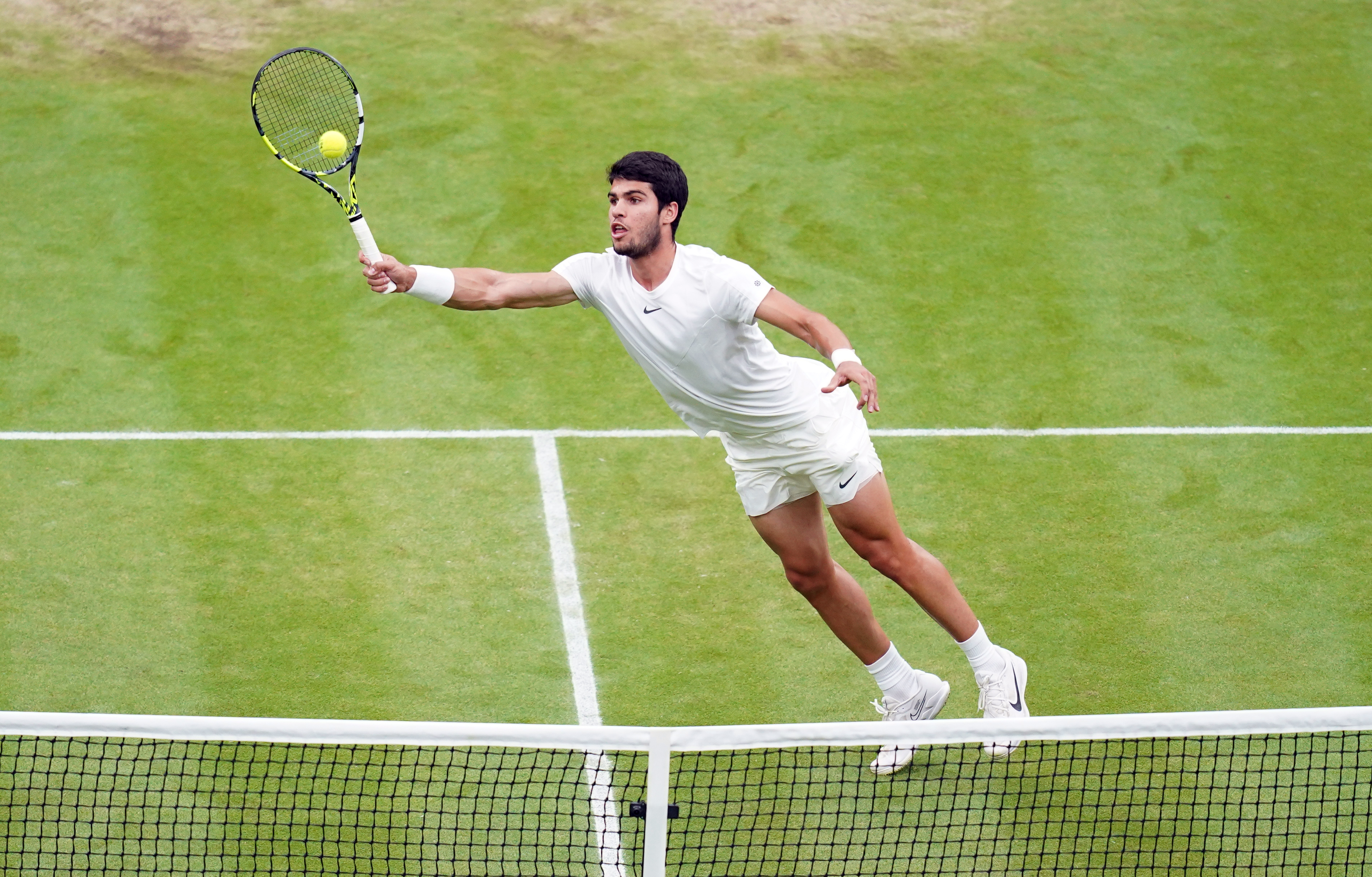 Carlos Alcaraz hits a volley on his way to the Wimbledon final
