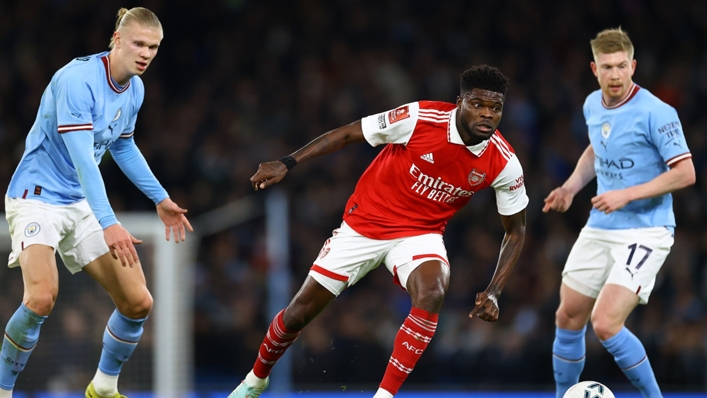 Arsenal's Thomas Partey cuts between Manchester City's Erling Haaland and Kevin De Bruyne