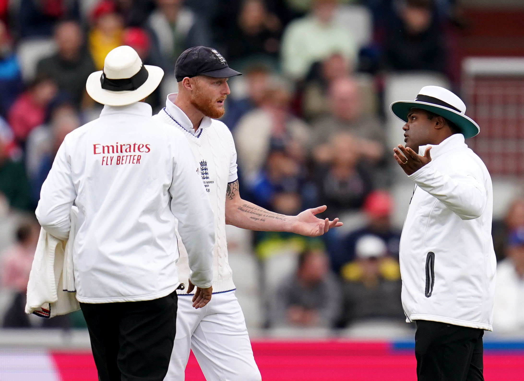 Ben Stokes speaks with umpires Joel Wilson (left) and Nitin Menon (right) as England were told not to use their fast bowlers due to bad light