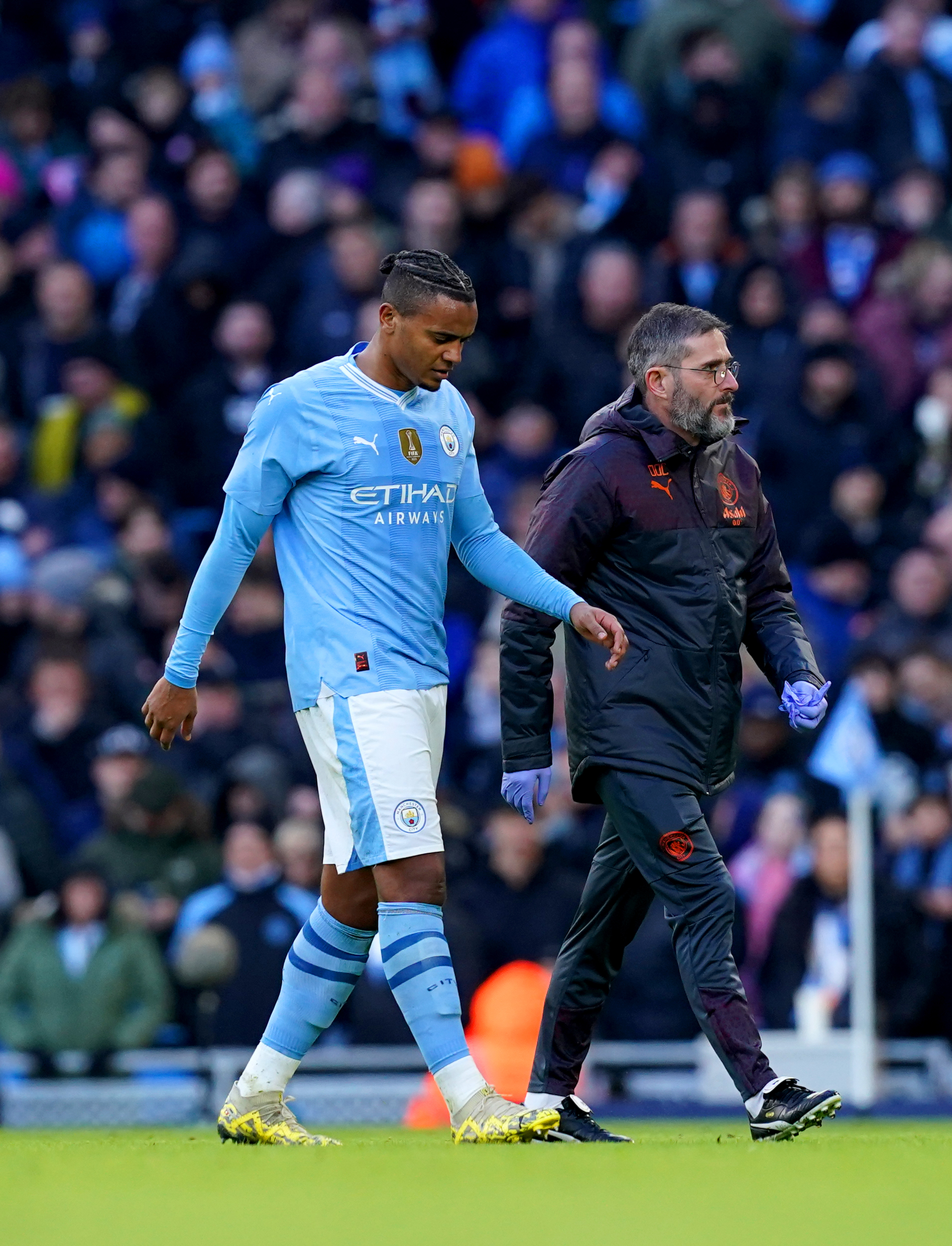 Manuel Akanji (left) limps off against Huddersfield