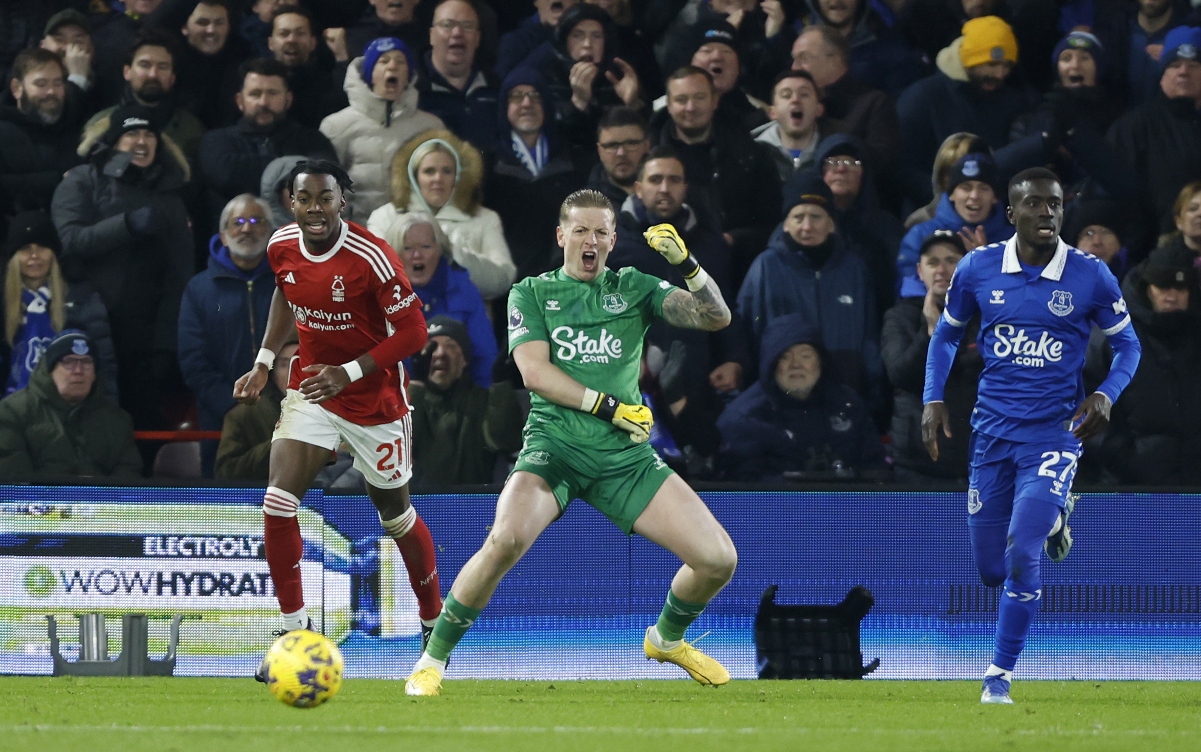 Jordan Pickford, centre, reacts after saving from Anthony Elanga, left