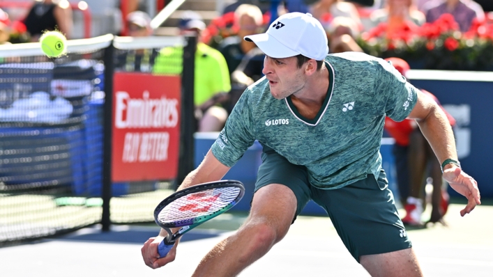 Hubert Hurkacz slides into the net to dig out a drop shot against Casper Ruud