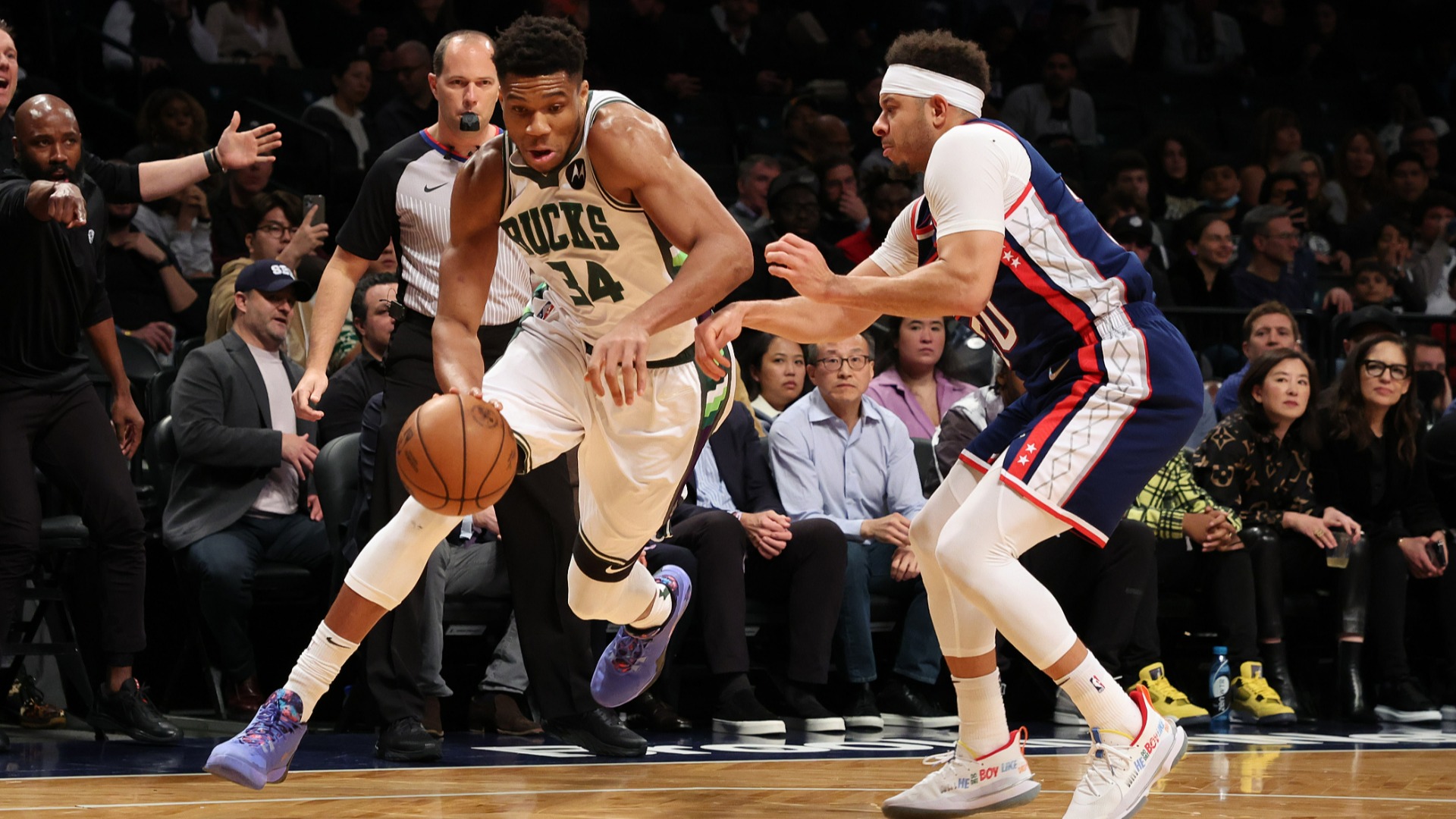 Giannis Antetokounmpo drives to the rim against Seth Curry.