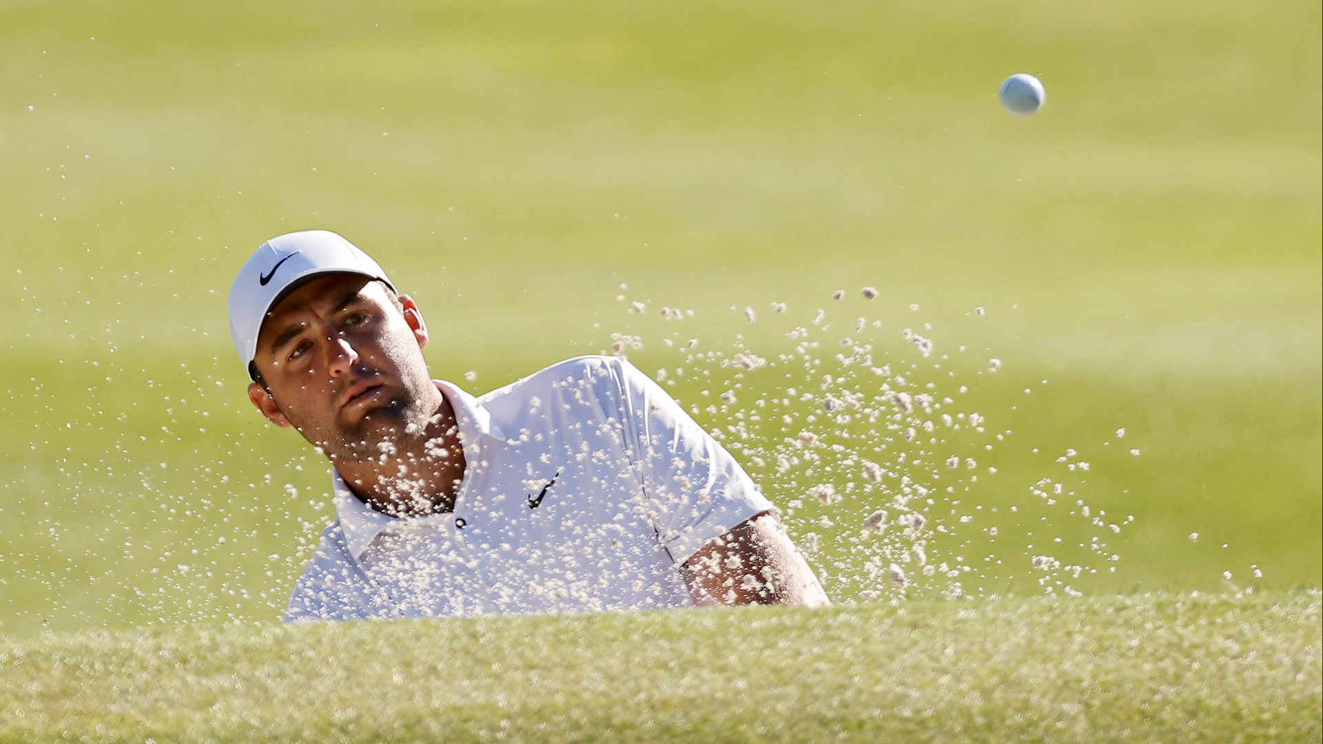 Scottie Scheffler works his way out of the bunker as he tries to defend his WGC Match Play title