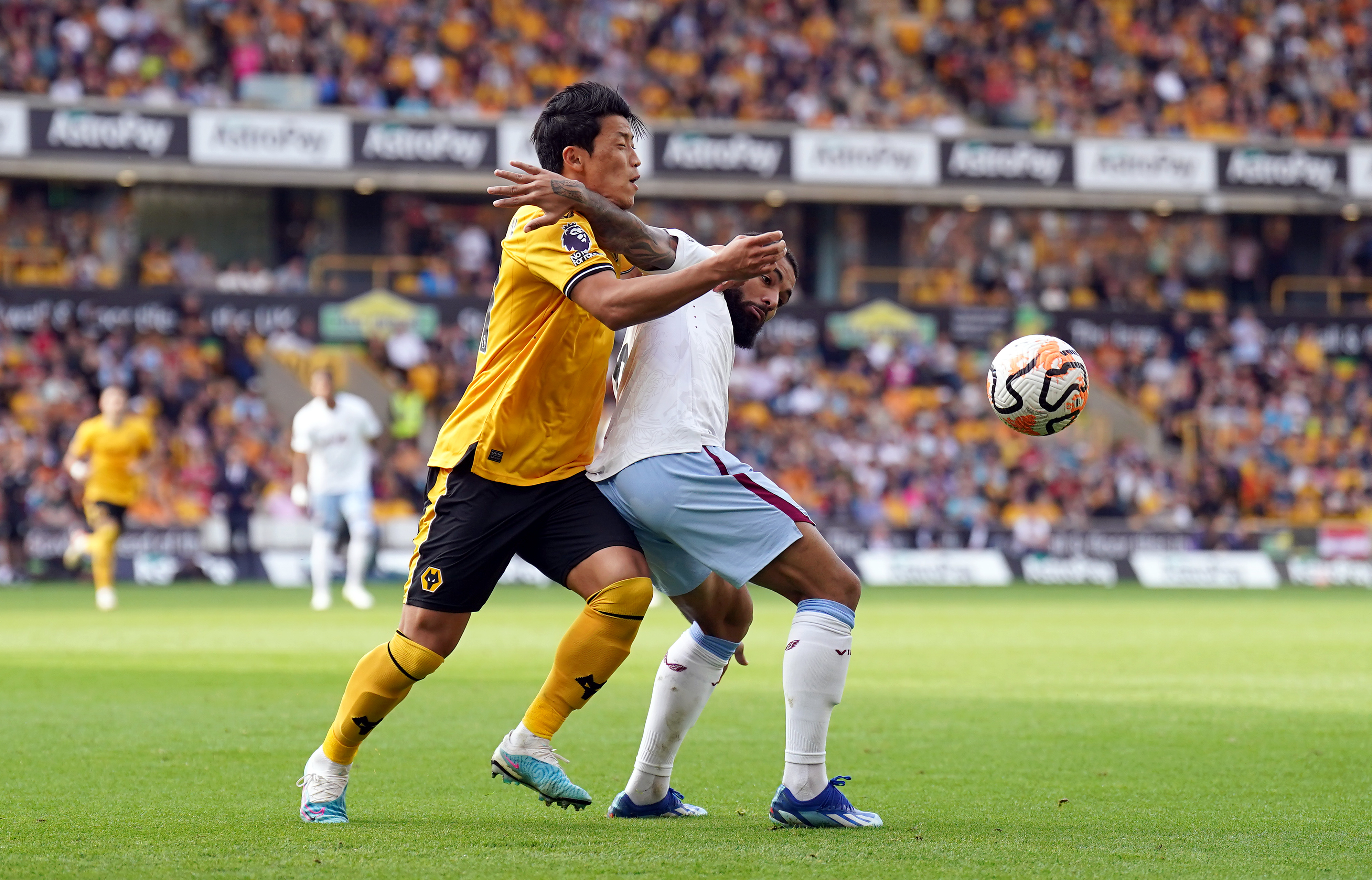 Villa midfielder Douglas Luiz and Wolves forward Hwang Hee-chan tussle for the ball at Molineux