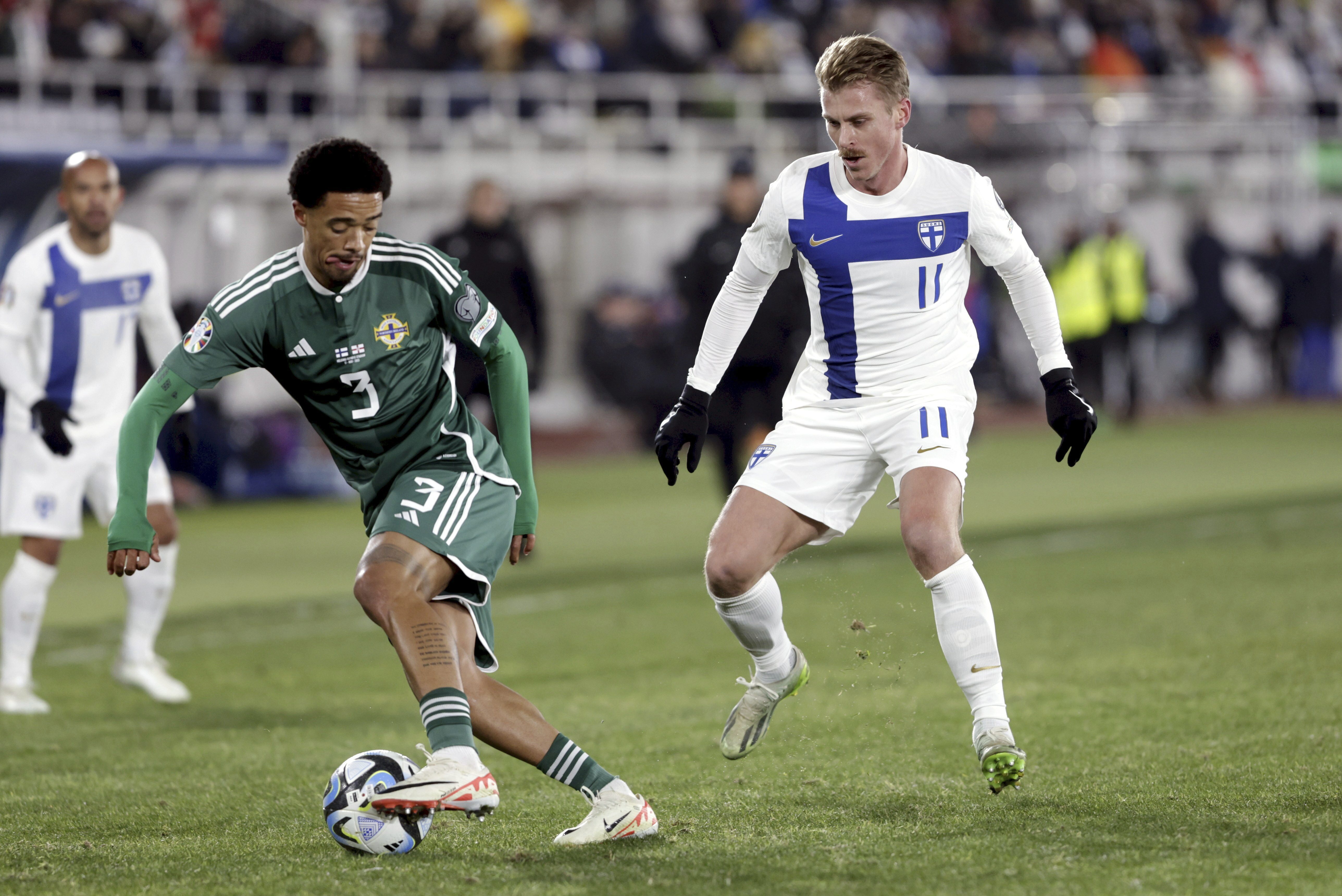 Jamal Lewis of Northern Ireland, left, is challenged by Rasmus Schuller (Roni Rekomaa/AP)