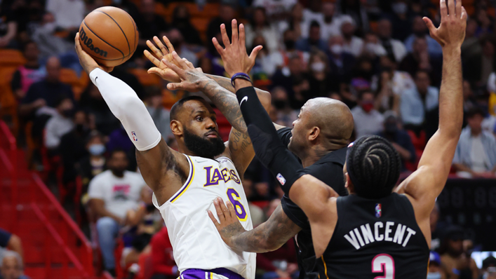 LeBron James of the Los Angeles Lakers passes around P.J. Tucker and Gabe Vincent of the Miami Heat