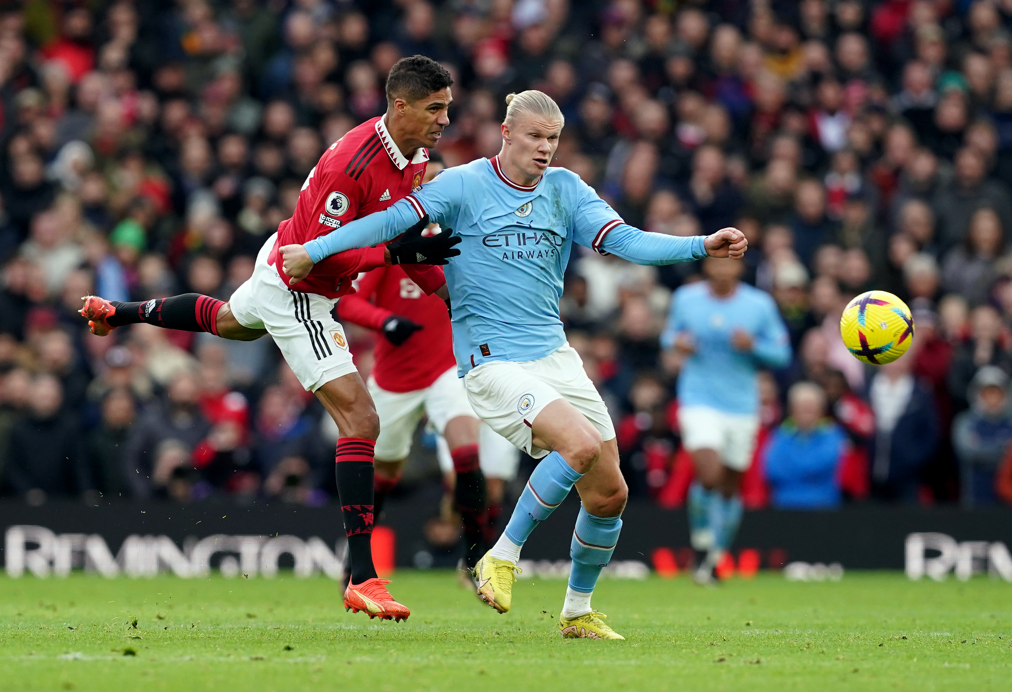 Manchester City’s Erling Haaland holds off Manchester United’s Raphael Varane