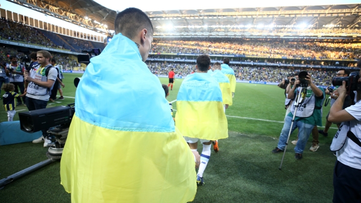 Dyamo Kyiv players walk onto the pitch ahead of their game against Fenerbahce draped in the Ukraine flag