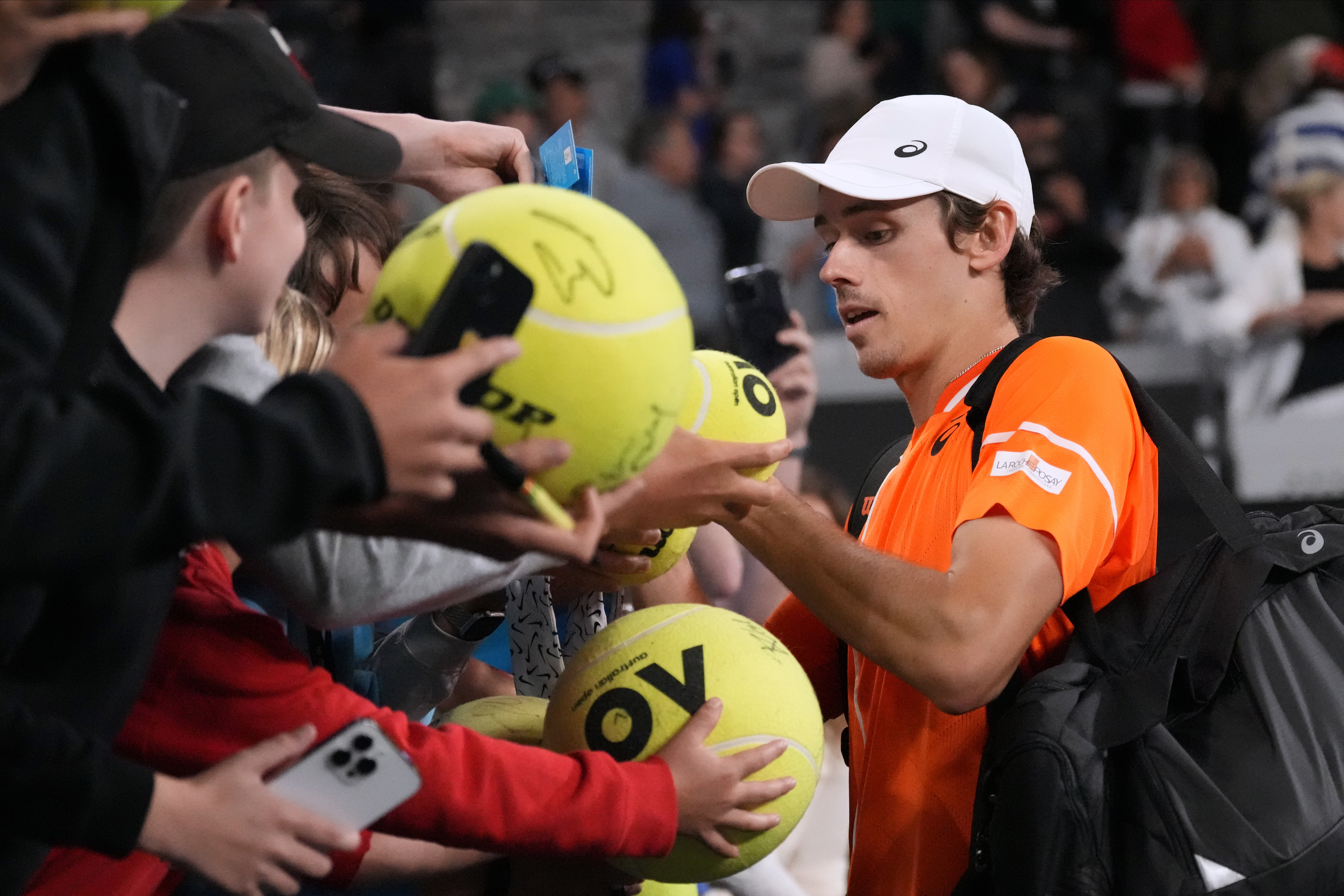 Alex De Minaur signs autographs