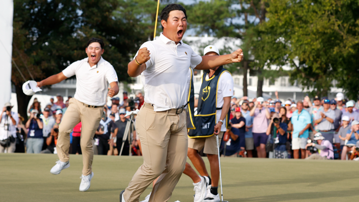 International Presidents Cup player Tom Kim reacts to making the winning putt of his match on the 18th hole as his partner Si Woo Kim celebrates in the background during the 2022 Presidents Cup four-ball